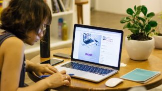 Image of a woman sat typing on a laptop