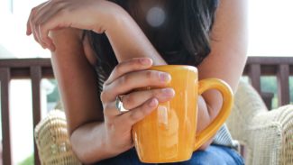 Person sat holding a mug