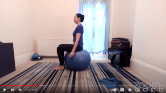 Side view of Ruth sitting on an exercise ball with her arms resting beside her