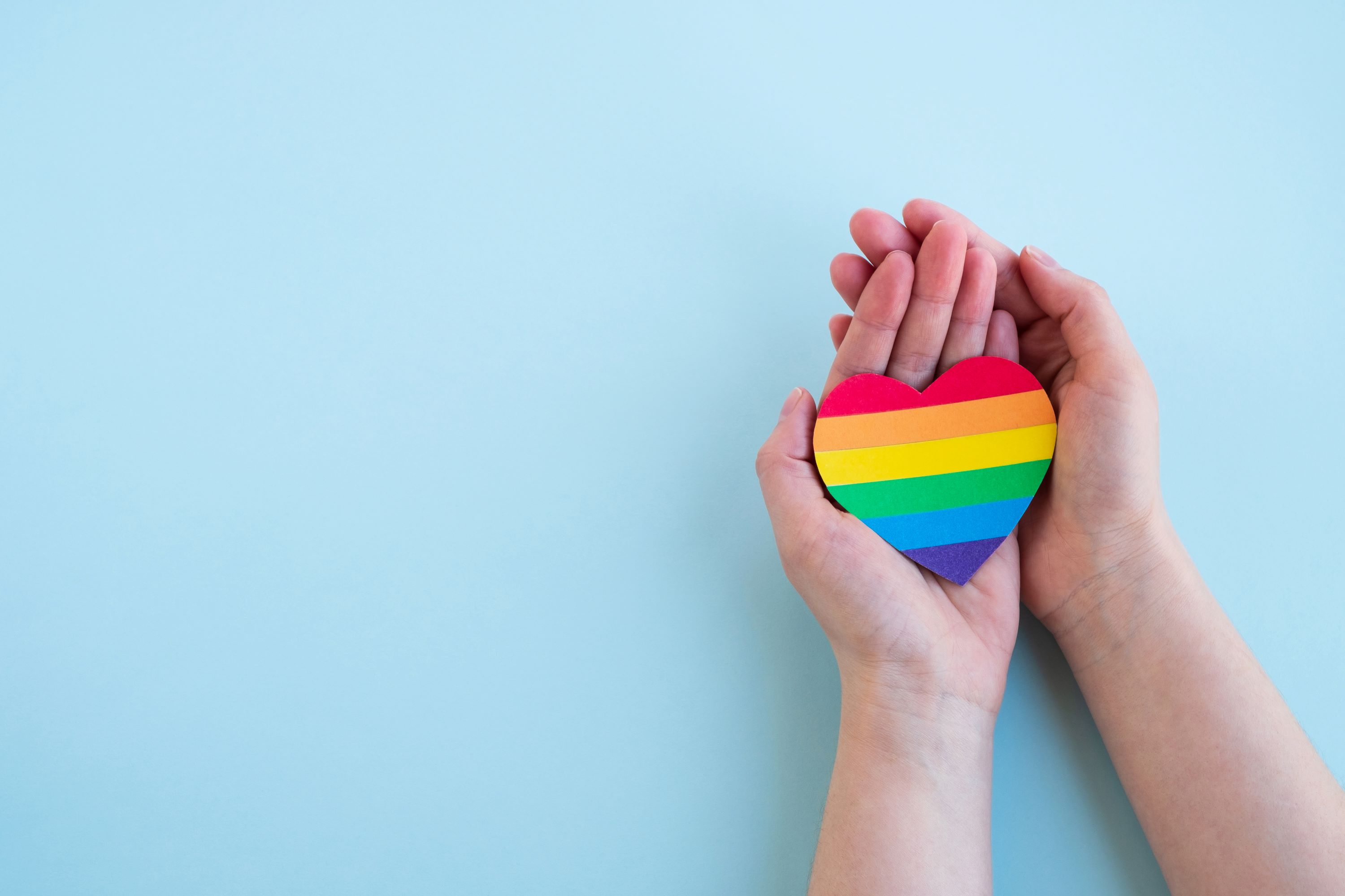 Image of heart with pride colours in hands